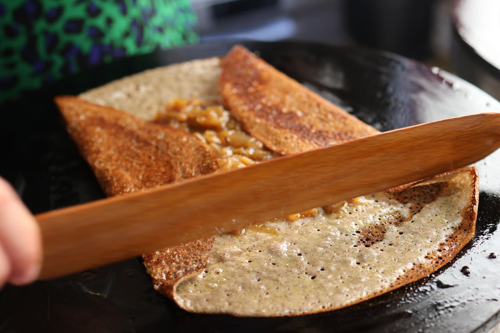 Une galette de sarrasin repliée sur le billig à la spatule en bois